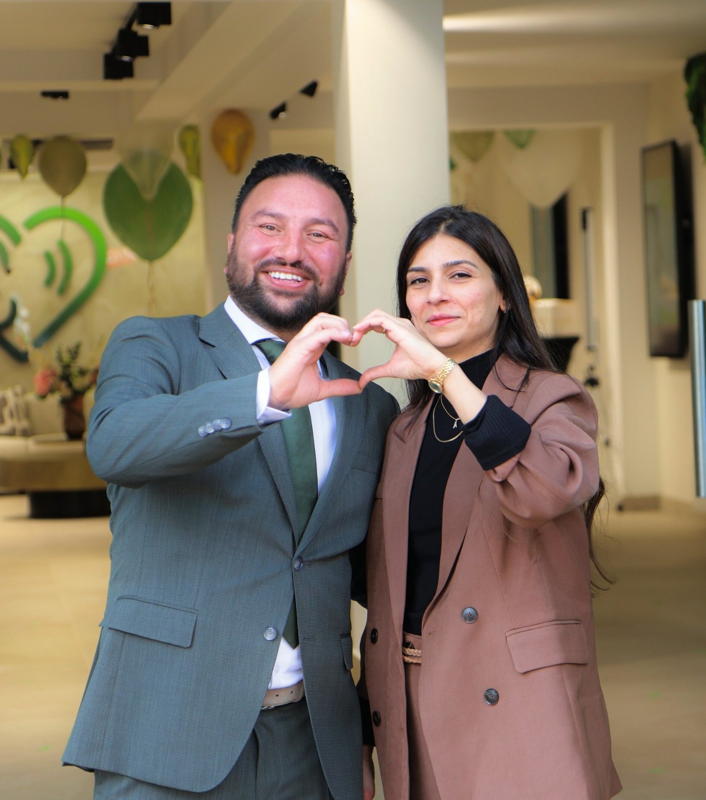 Mushraf en Amber maken samen een hart met hun handen in Hoorcentrum Westland